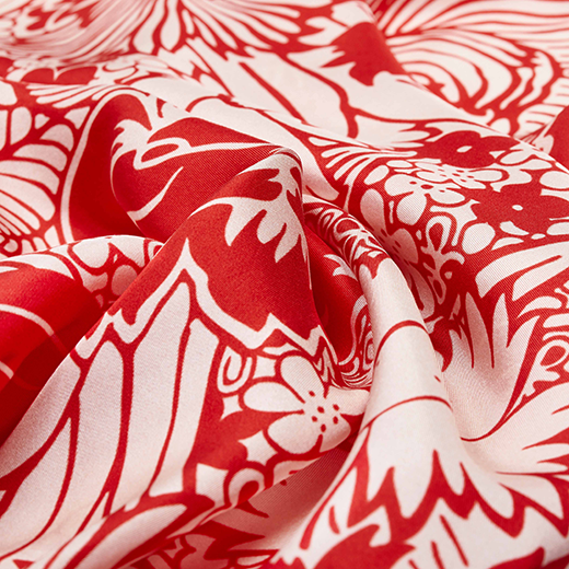 A close up of a red floral pattern of a silk scarf.